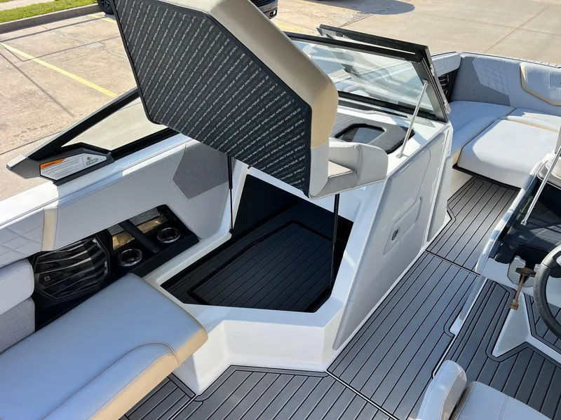 Slide: The Image of 2024 Nautique G25 boat interior with open storage compartment and seating. - 31