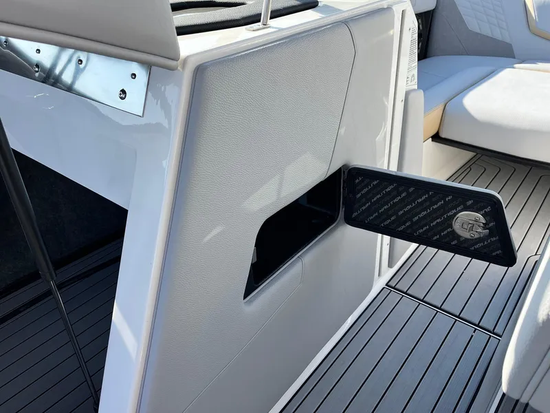 Slide: The Image of 2024 Nautique G25 boat interior with open storage compartment and sleek seating. - 33