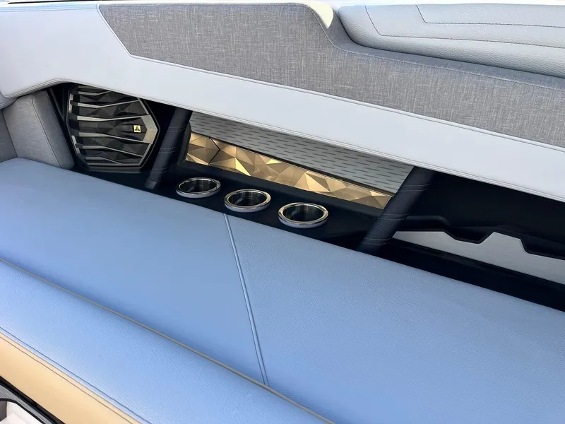 Slide: The Image of 2024 Nautique G25 interior with blue upholstery and cup holders. - 41