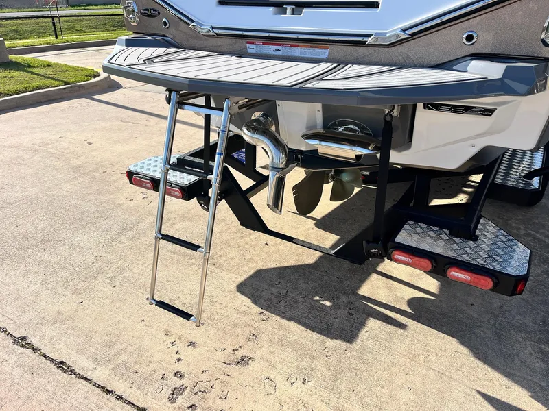 Slide: The Image of 2024 Nautique G25 boat with ladder and propeller, parked on concrete. - 9