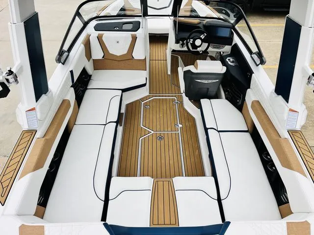 Slide: The Image of 2024 Nautique G23 boat interior with white seating and teak flooring. - 11