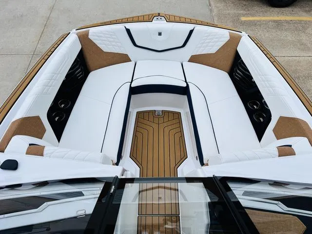 Slide: The Image of 2024 Nautique G23 boat interior with white and tan seating, teak flooring. - 14