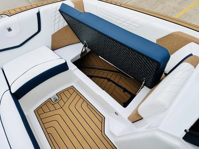 Slide: The Image of 2024 Nautique G23 boat interior with blue and white seating and teak flooring. - 16