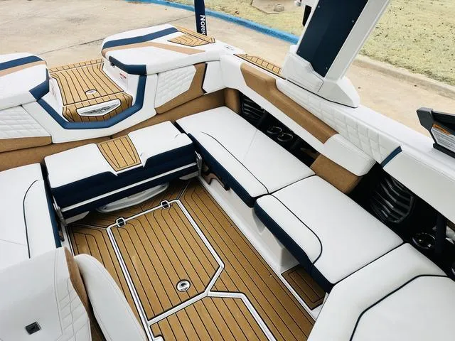 Slide: The Image of 2024 Nautique G23 boat interior with luxurious seating and teak flooring. - 18