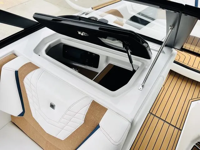Slide: The Image of 2024 Nautique G23 boat interior with open storage compartment and stylish seating. - 23