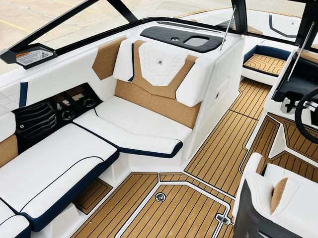 Slide: The Image of 2024 Nautique G23 boat interior with luxurious seating and teak flooring. - 25
