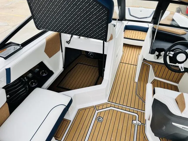 Slide: The Image of 2024 Nautique G23 boat interior with stylish seating and wood-patterned flooring. - 26