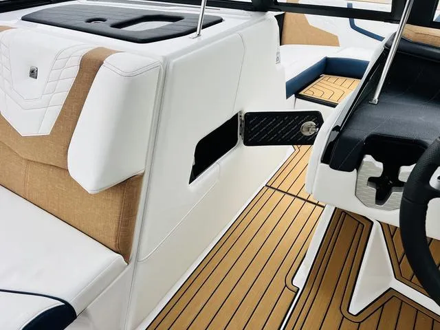 Slide: The Image of 2024 Nautique G23 interior with tan and white upholstery, sleek design, and modern features. - 28