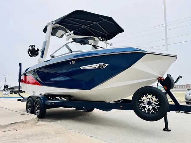 Slide: The Image of 2024 Nautique G23 boat with blue and white hull on a trailer. - 3