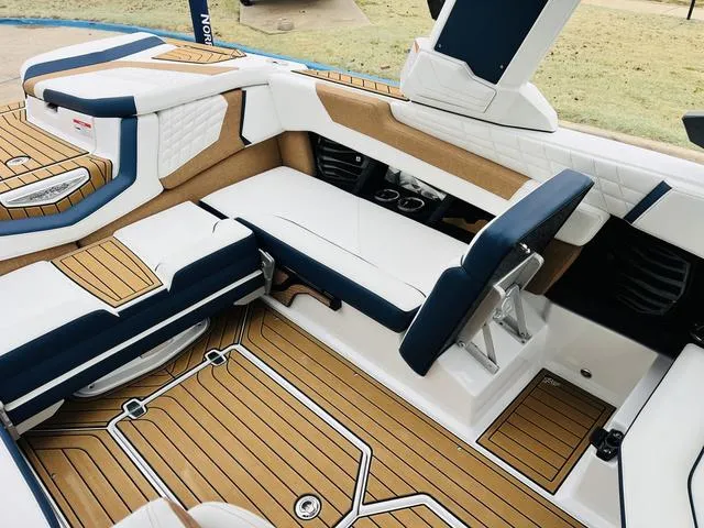 Slide: The Image of 2024 Nautique G23 boat interior with luxurious seating and teak flooring. - 30