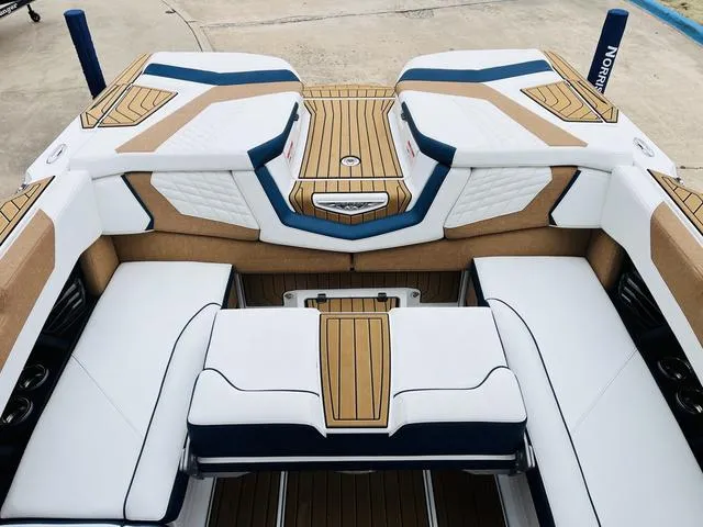 Slide: The Image of 2024 Nautique G23 boat interior with luxurious white and tan seating and teak accents. - 33
