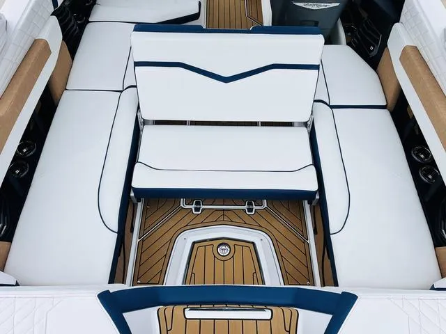 Slide: The Image of 2024 Nautique G23 boat interior with white and blue seating, teak flooring. - 36