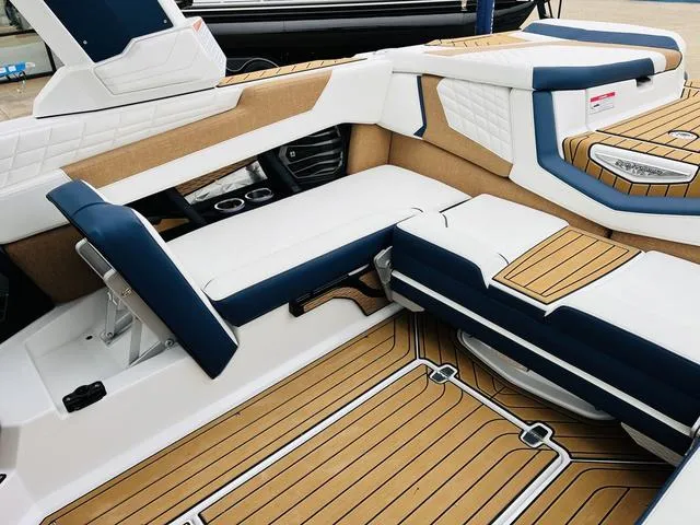 Slide: The Image of 2024 Nautique G23 boat interior with luxurious seating and teak flooring. - 41