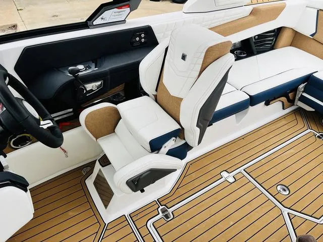 Slide: The Image of 2024 Nautique G23 boat interior with luxurious seating and teak flooring. - 44