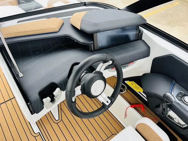 Slide: The Image of 2024 Nautique G23 boat dashboard with modern steering wheel and control panel. - 46