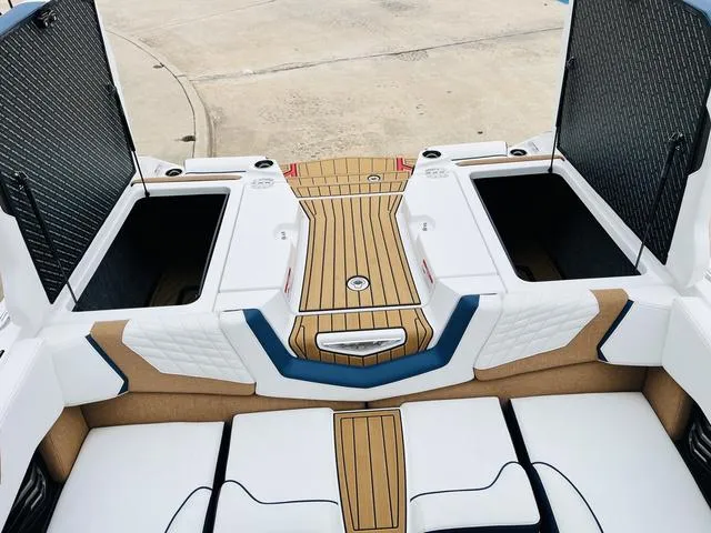 Slide: The Image of 2024 Nautique G23 boat interior with open storage compartments and teak-style flooring. - 48