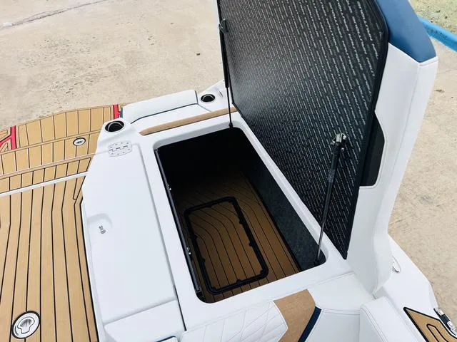Slide: The Image of 2024 Nautique G23 boat storage compartment with open lid, showcasing interior space. - 49