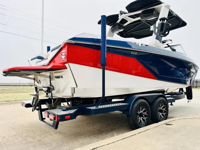 Slide: The Image of 2024 Nautique G23 boat on trailer, featuring red, white, and blue design. - 5