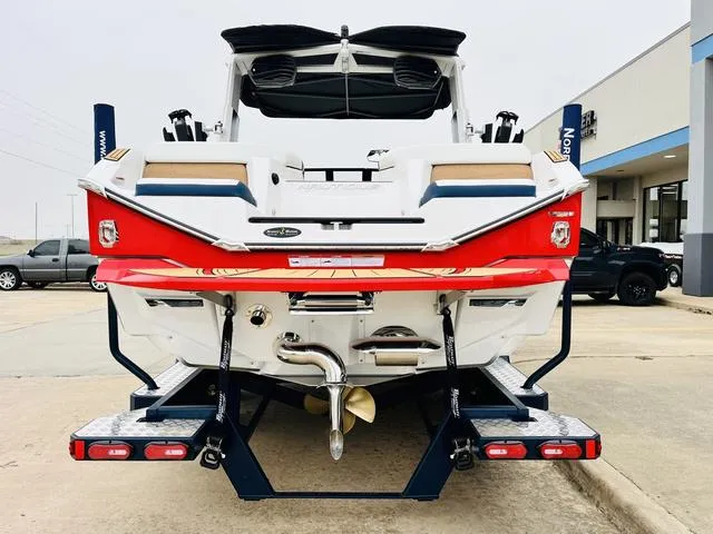 Slide: The Image of 2024 Nautique G23 boat, rear view, showcasing sleek design and vibrant red accents. - 6