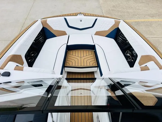 Slide: The Image of 2024 Nautique G23 boat interior with luxurious seating and teak flooring. - 12
