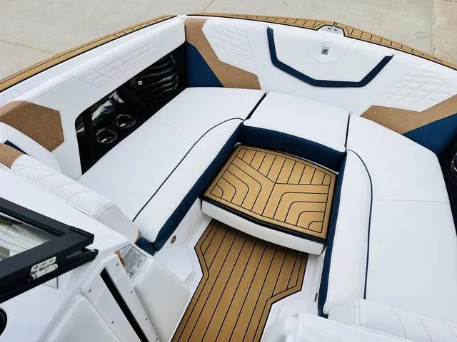 Slide: The Image of 2024 Nautique G23 boat interior with white and tan seating, elegant design. - 13