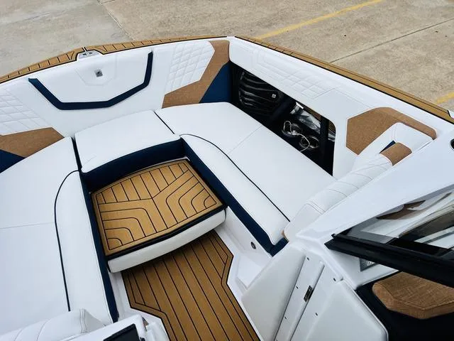 Slide: The Image of 2024 Nautique G23 boat interior with white and tan seating, modern design. - 14