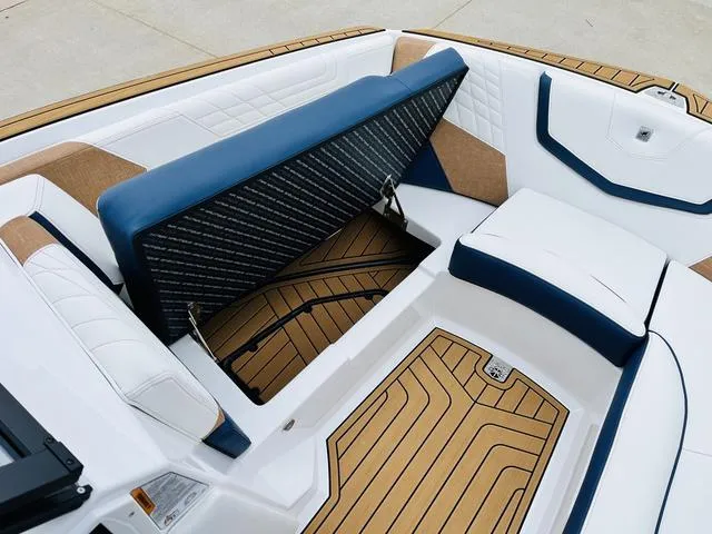 Slide: The Image of 2024 Nautique G23 boat interior with open storage compartment and cushioned seating. - 17
