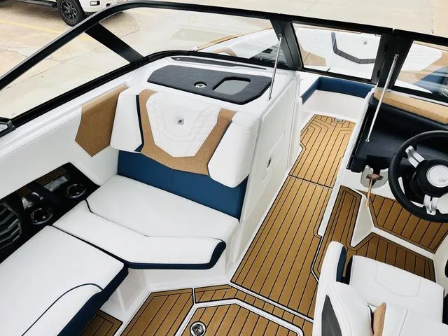 Slide: The Image of 2024 Nautique G23 boat interior with white and blue seating, teak flooring. - 20