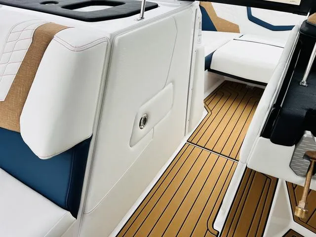 Slide: The Image of 2024 Nautique G23 interior with white and tan upholstery, teak-style flooring. - 27