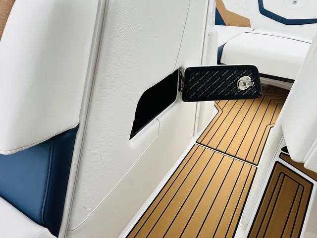 Slide: The Image of 2024 Nautique G23 interior with white and blue seating, teak-style flooring. - 28