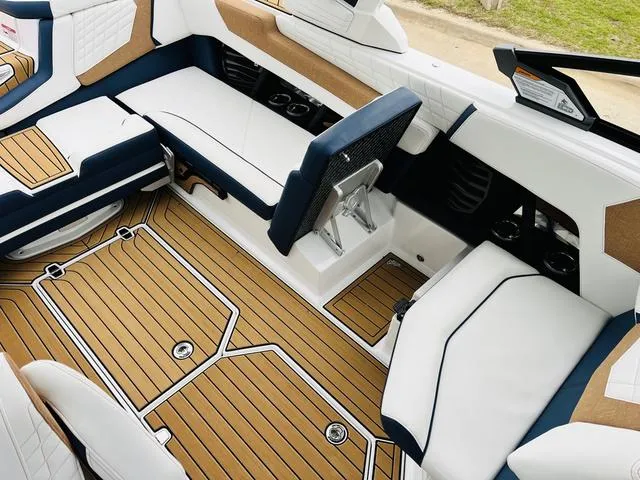 Slide: The Image of 2024 Nautique G23 boat interior with luxurious seating and teak-style flooring. - 30