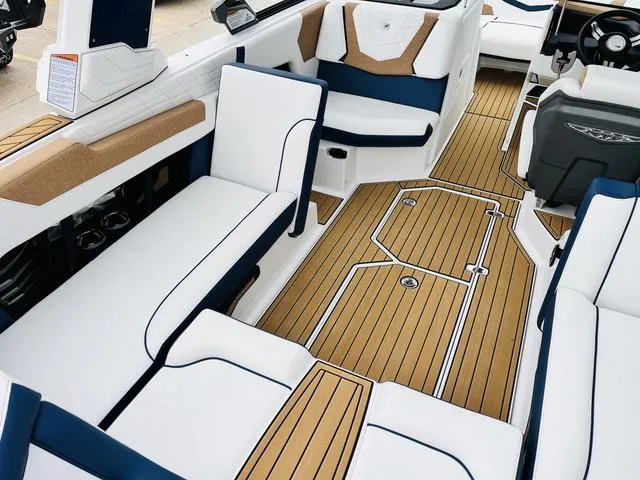 Slide: The Image of 2024 Nautique G23 boat interior with white and tan seating, teak-style flooring. - 31