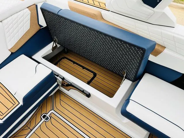 Slide: The Image of 2024 Nautique G23 boat interior with open storage compartment and cushioned seating. - 33