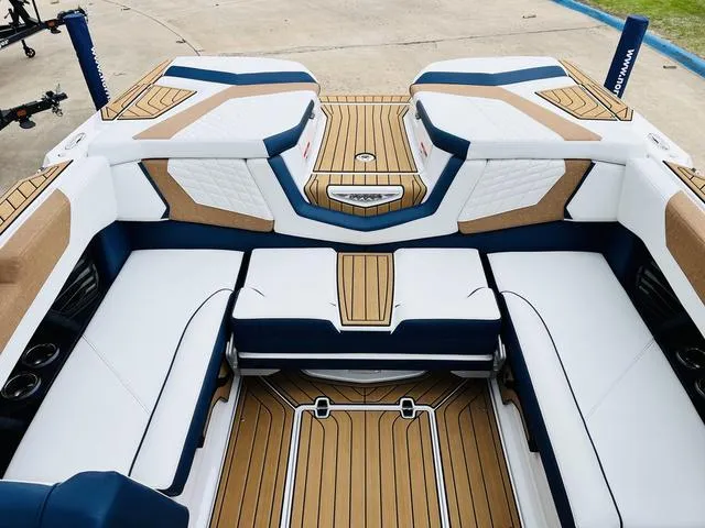 Slide: The Image of 2024 Nautique G23 boat interior with white and blue seating, teak flooring. - 34