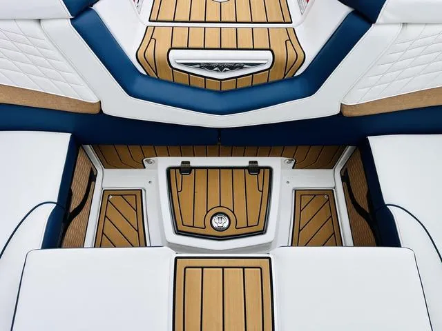 Slide: The Image of 2024 Nautique G23 boat interior with teak flooring and white-blue upholstery. - 38