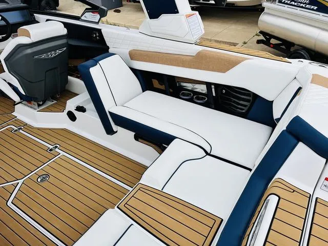 Slide: The Image of 2024 Nautique G23 boat interior with white and blue seating, teak flooring. - 42