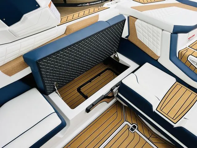 Slide: The Image of 2024 Nautique G23 boat interior with open storage compartment, featuring blue and white seating. - 43