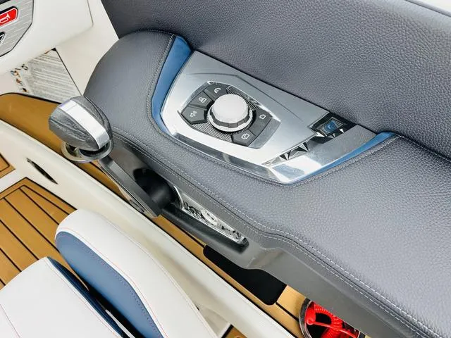 Slide: The Image of 2024 Nautique G23 boat interior with control panel and luxurious seating. - 47