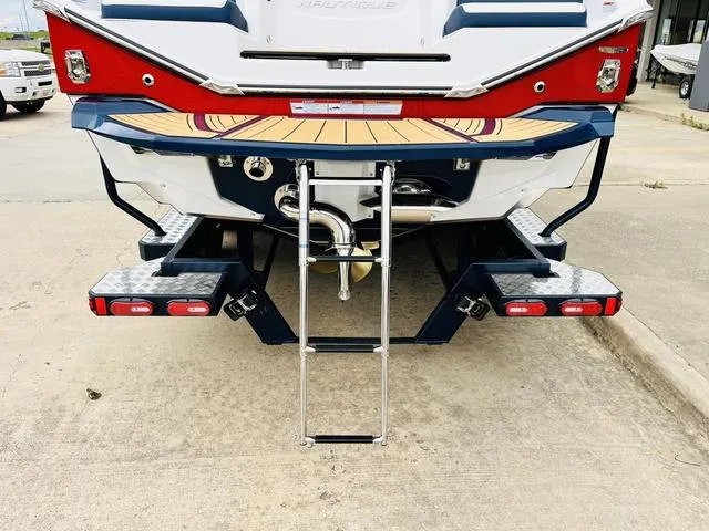 Slide: The Image of 2024 Nautique G23 boat rear view with swim platform and ladder. - 8