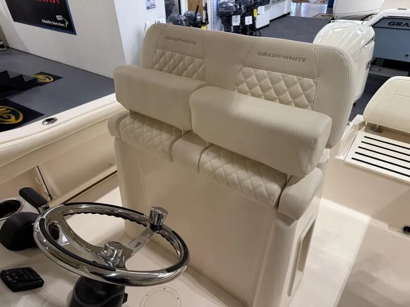Slide: The Image of 2025 Grady-White Fisherman 216 boat interior with steering wheel and cushioned seating. - 2
