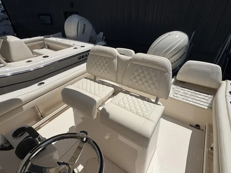 Slide: The Image of 2025 Grady-White Fisherman 216 boat interior with white cushioned seating and Yamaha engines. - 10