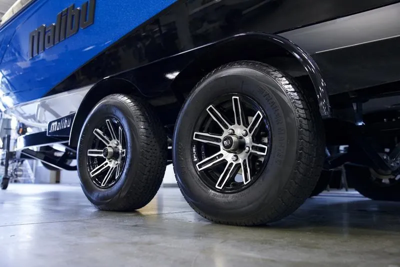 Slide: The Image of 2024 Malibu 23 LSV boat trailer with dual wheels in a garage. - 5