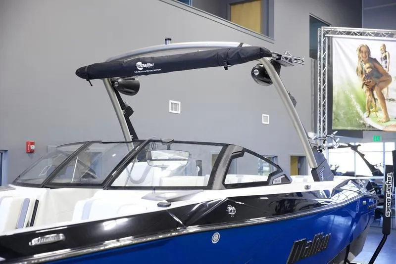 Slide: The Image of 2024 Malibu 23 LSV boat in showroom, featuring sleek design and modern wakeboard tower. - 6