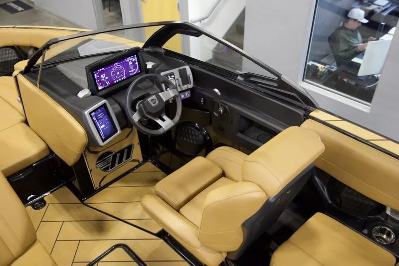 Slide: The Image of 2024 Malibu 23 LSV boat interior with modern dashboard and tan seating. - 11