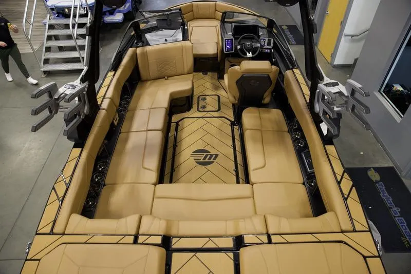 Slide: The Image of 2024 Malibu 23 LSV boat interior with tan seating and modern dashboard. - 15