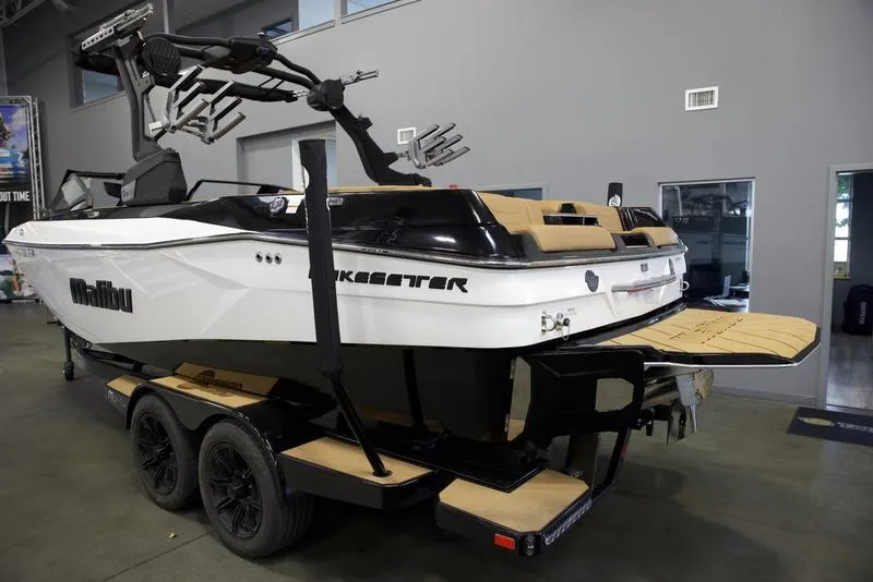 Slide: The Image of 2024 Malibu 23 LSV boat on trailer in showroom, rear view. - 18