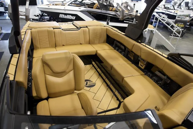 Slide: The Image of 2024 Malibu 23 LSV boat interior with tan leather seating in showroom. - 5