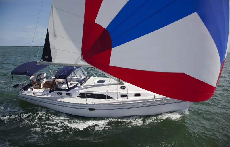 Slide: The Image of 2025 Catalina 386 sailboat with colorful spinnaker sailing on open water. - 2