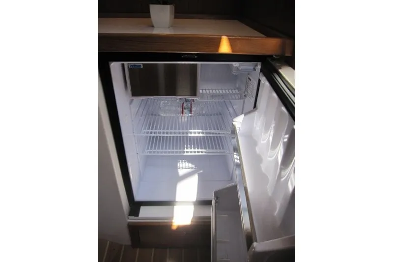 Slide: The Image of Open refrigerator in Catalina 386, 2025 model, with wooden countertop and empty shelves. - 26