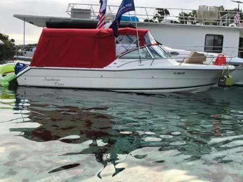 The Image of 1998 Pursuit 2460 Denali boat with red canopy on calm water. - 0